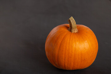 Orange, yellow pumpkin lies on a black background