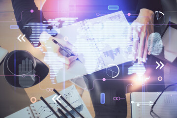 Multi exposure of hands making notes with world map hologram and data theme icons. Concept of global data.