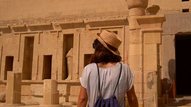 A young woman with a face mask visiting the Funerary Temple of Hatshepsut in Luxor, Egypt. Return of tourism to egypt in the coronavirus pandemic, covid-19