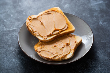 Peanut butter toast or sandwich isolated, dark background with copy space.