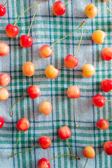 Fresh homemade ripe sweet cherries on squared fabric background. Summer still life