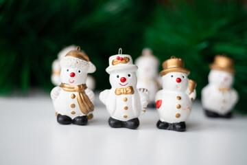 Christmas snowmen on the background of green branches