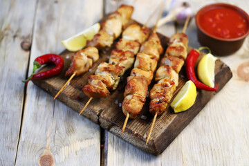 Selective focus. Appetizing chicken skewers on wooden sticks. Rustic style.