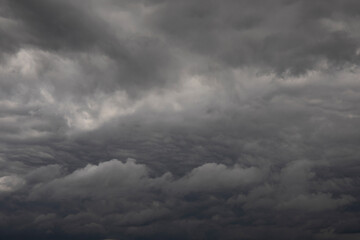 Naklejka na ściany i meble Natural background of dark stormy clouds in gray sky