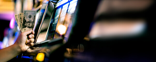 Slot Machine Play Time. Female Gambler Hand hold money bill ready to win the game with one best shot casino close up