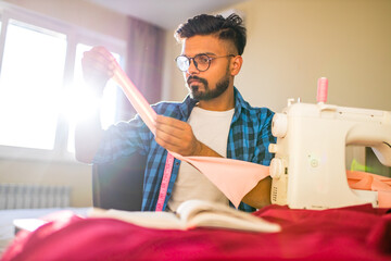 indian man sewing new collection in showroom in living room