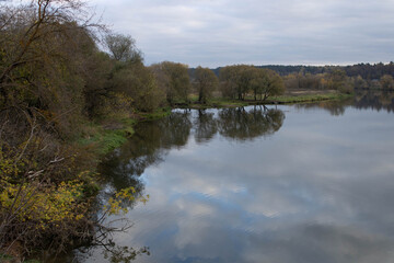 river in the park on an autumn day, the waters look brownish yellow,