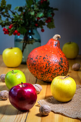 apples, pumpkin and hawthorn on a wooden table