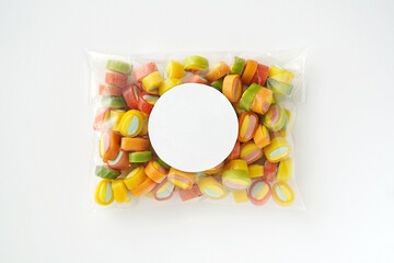 Kids party plastic favor bag with empty round sticker mockup with colorful candies for thank you...