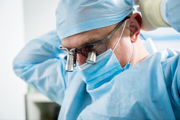 Spinal surgeon in operating room with surgery equipment.