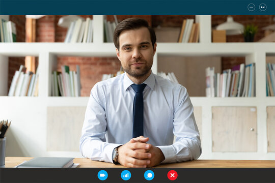 Head shot portrait screen view confident businessman wearing suit sitting at workplace, engaged in online conference, negotiations with business partners, hr manager leading internet job interview