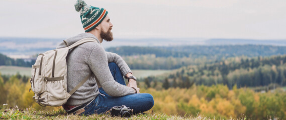 Young man traveler sitting on top of the hill enjoy nature, Travel and active lifestyle concept,...