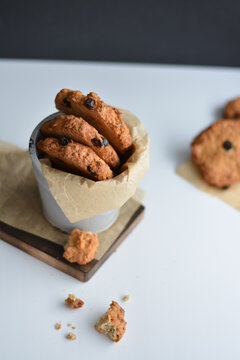 Gray jar with homemade oatmeat cookies on wooden board. 
