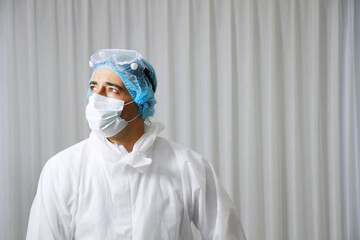 Professional Medical Caucasian man is wearing mask and  Personal Protective Equipment or PPE clothing is Healing for patient infected with the Covid-19 virus in hospital of Thailand