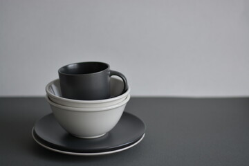 Empty black and gray monochrome plate and cup served with kitchen checkered towel. Minimalism food restaurant. Mock and copy space. Food desing.