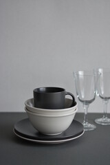 Empty black and gray monochrome plate and cup served with kitchen checkered towel. Minimalism food restaurant. Mock and copy space. Food desing.