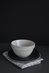 Empty black and gray monochrome plate and cup served with kitchen checkered towel. Minimalism food restaurant. Mock and copy space. Food desing.