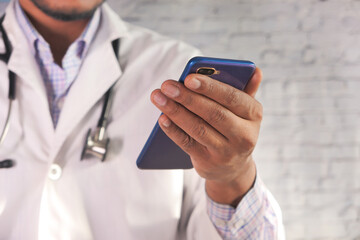 doctor in white coat using a smartphone.