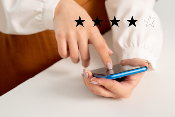 Women's hands with mobile phone and star rating icon