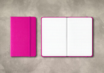 Pink closed and open lined notebooks on concrete background