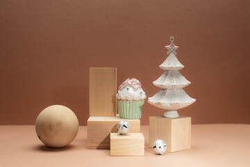 Conceptual trendy Christmas or New Year card with wooden podiums,wooden ball,Christnas tree and jingle bells on monochrome beige background.