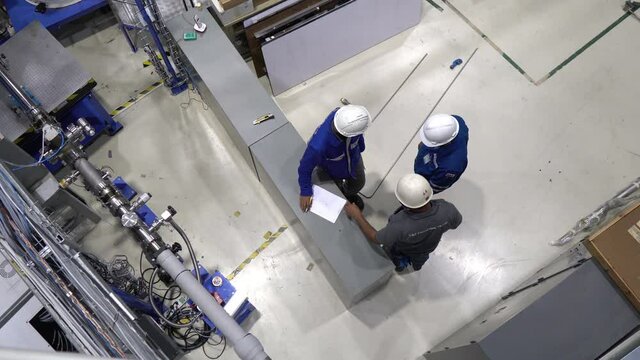 Group of engineers working  in the large factory