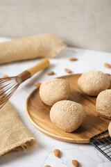 Gluten free Keto bread. Homemade ketogenic buns with sesame seeds. set on white cafe table.
