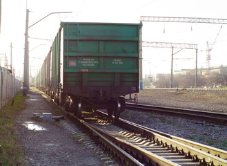 Fototapeta na wymiar The last car of a departing train. Freight cars in a moving freight train. Transportation by rail. Russia. Krasnoyarsk. October 17, 2020