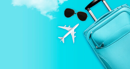 Blue suitcase with sunglasses, airplane on pastel blue background. travel concept. Minimal style - Flat lay top view