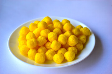 Yellow round corn snacks on a white plate