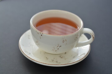 A white ceramic cup of fruit tea on black background. Copy space.