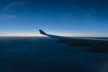 Fototapeta na wymiar Wing of a airplane at sunrise at an altitude of 11 km.
