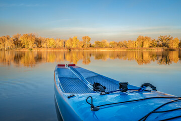 Racing stand up paddleboard with a safety leash on a calm lake in fall scenery in northern Colorado.