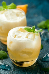 Refreshing Cantaloupe Melon cocktail with ice and mint on rustic table