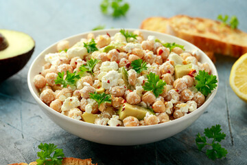 Chickpeas salad with feta cheese, avocado and herbs in white bowl. healthy food