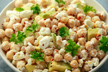 Chickpeas salad with feta cheese, avocado and herbs in white bowl. healthy food