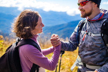 Hikers newwedding with backpacks relaxing on top of a mountain in honeymoon