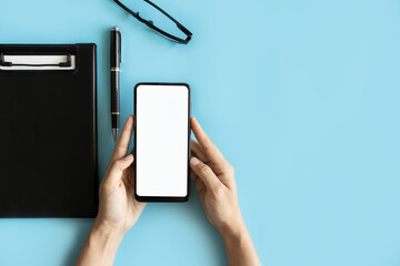 Empty screen Smart phone and file folder on business desk office with copy space, Top view