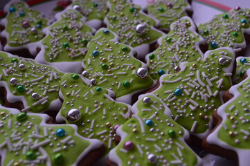 Christmas ginger cookies at green tree and many candy for background