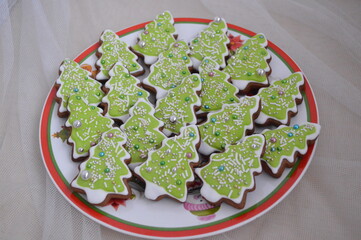Christmas ginger cookies at green tree and many candy for background