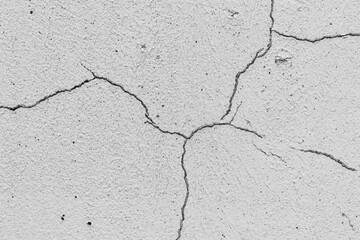 Grey textured plaster as a background.Cracks in the wall