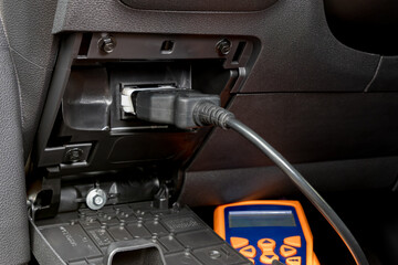 Engine scan tool plugged into car computer connection. Concept of automotive repair, maintenance,...
