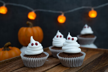 Halloween ghost cupcakes , homemade sweet chocolate muffins with meringue ghost