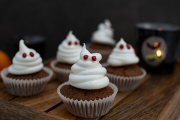 Halloween ghost cupcakes , homemade sweet chocolate muffins with meringue ghost