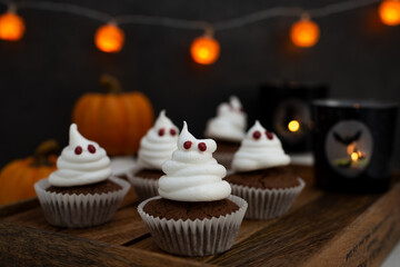 Halloween ghost cupcakes , homemade sweet chocolate muffins with meringue ghost