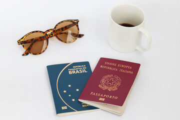 Flat lay italian and brazilian passport travel and organization concept, white background, coffee, sunglasses.