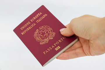 Close up of woman hand delivering or showing official italian passport on white background and isolate.