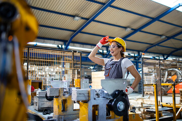 Female factory worker operating industrial machine in production line.