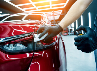 Car service worker applying nano coating on a car detail.