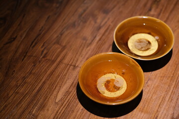 high angle view of two retro bowls of Chinese wine on wooden table. 